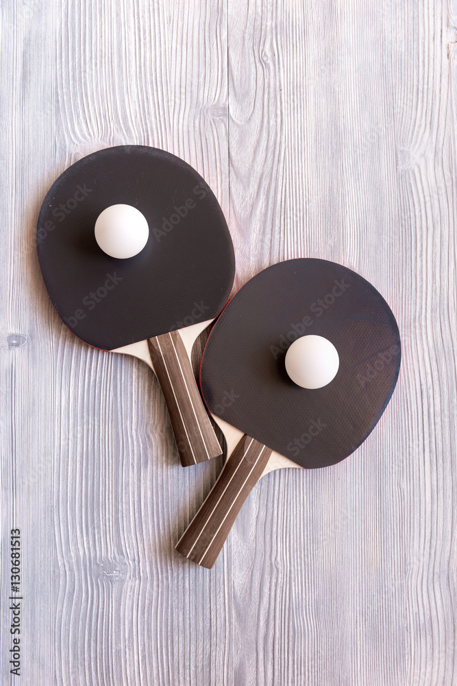 black racket for ping pong ball wooden background top view