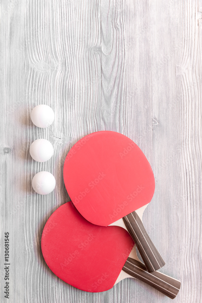 Red racket for ping pong ball wooden background top view