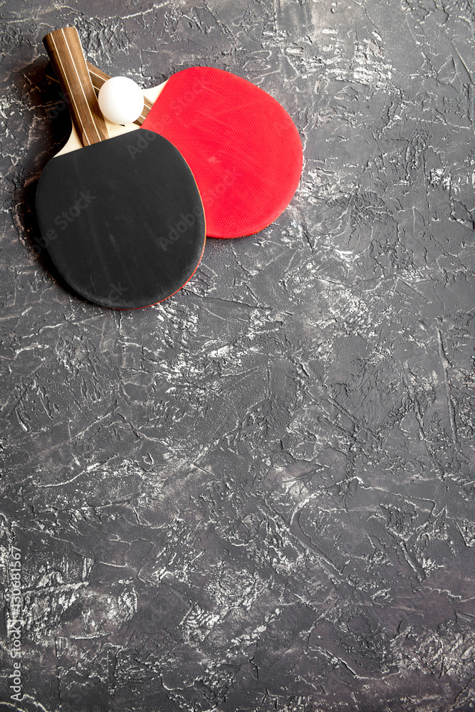 black racket for ping pong ball gray background top view