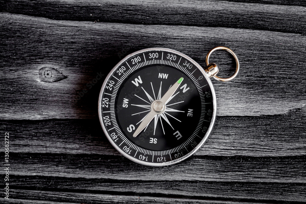 compass on dark wooden background concept direction motion top view