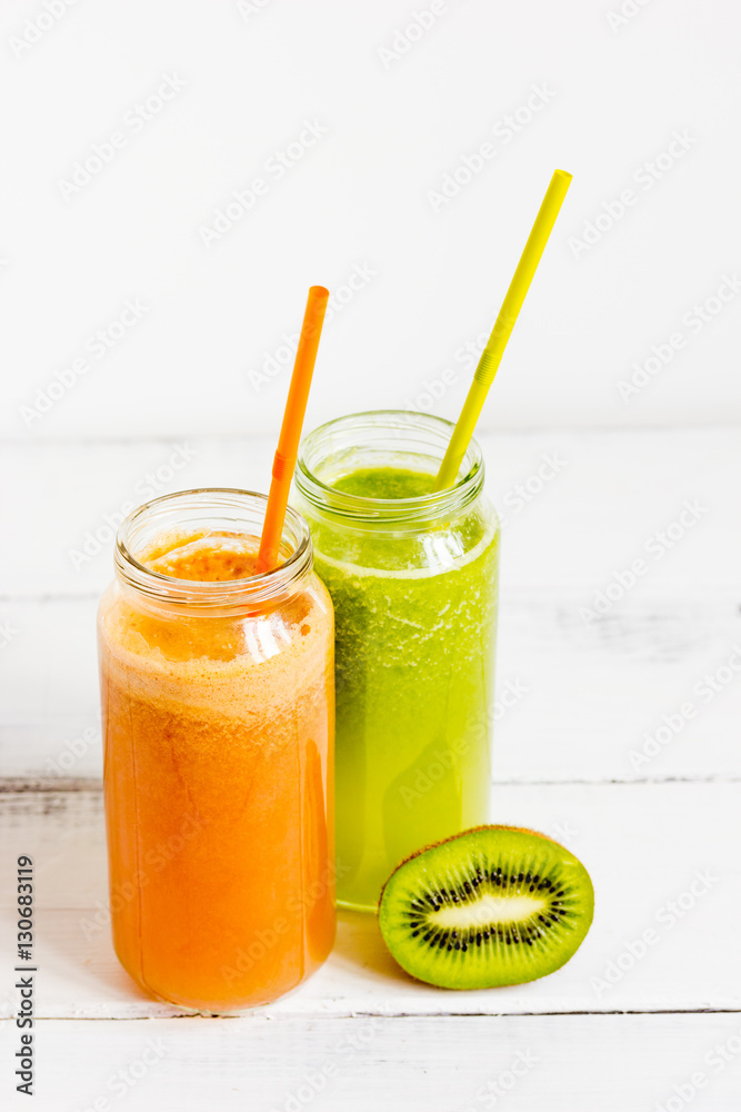 Fresh detox juices in glass bottles on white background