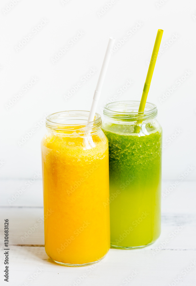 Fresh detox juices in glass bottles on white background