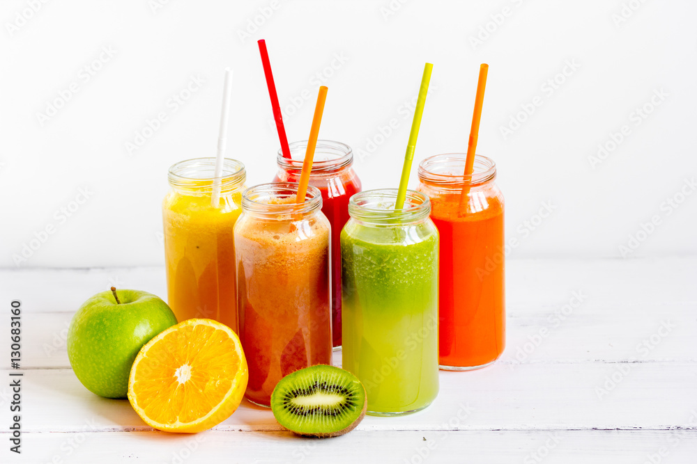 Fresh detox juices in glass bottles on white background