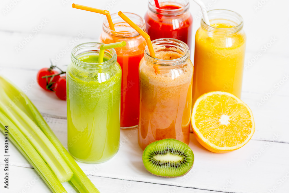 Fresh detox juices in glass bottles on white background