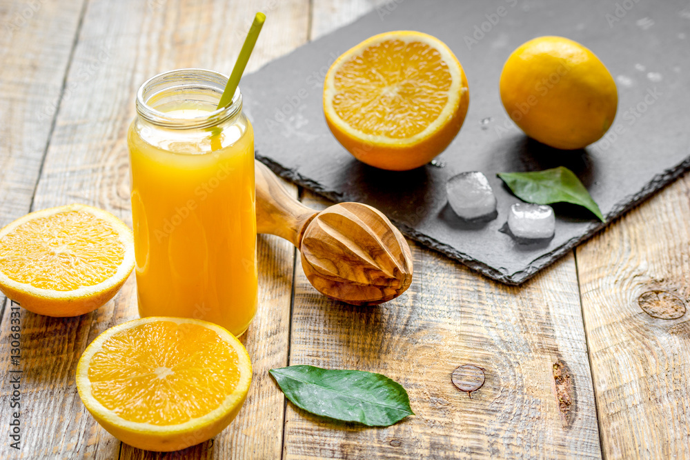 freshly squeezed orange juice in glass bottle on wooden background