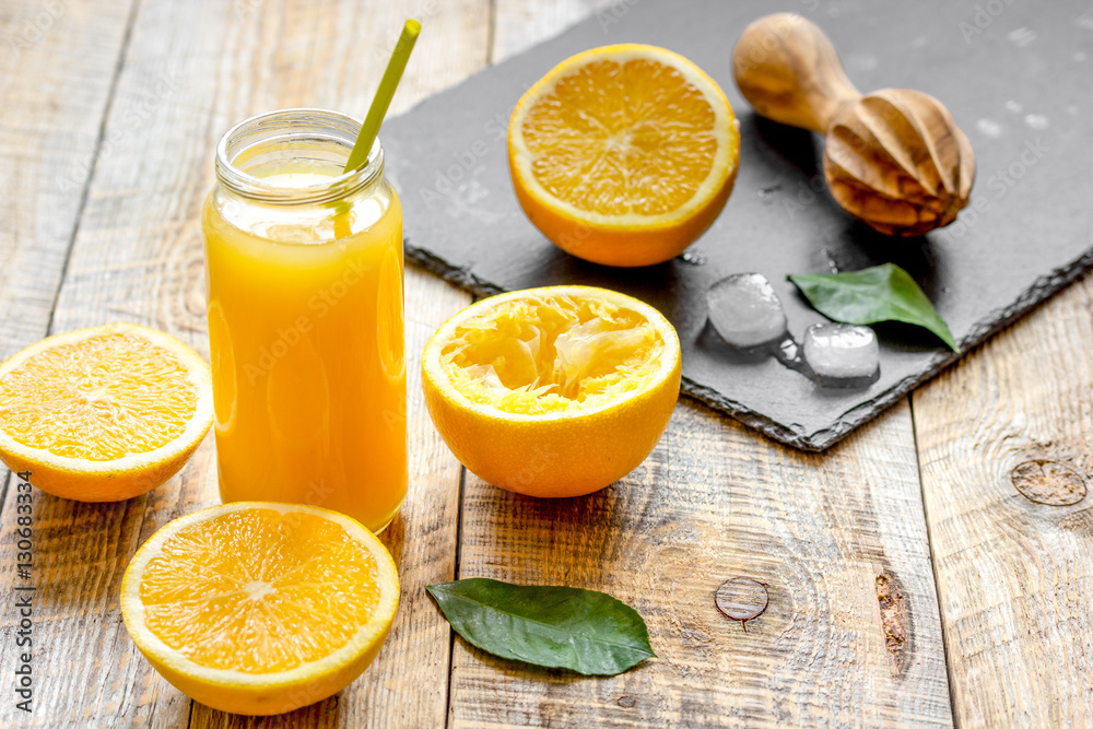 freshly squeezed orange juice in glass bottle on wooden background