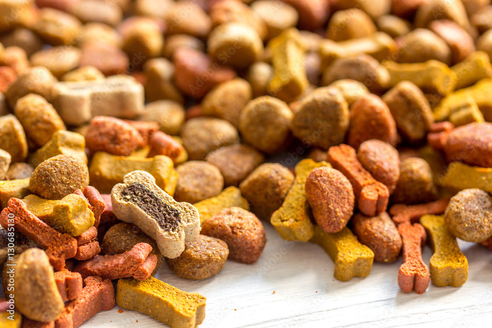 dry dog food in bulk on wooden background close up