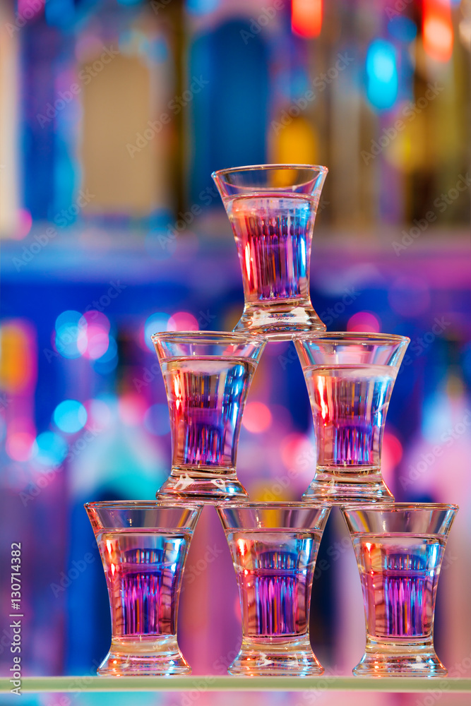 Pyramid of six shot glasses with cocktails