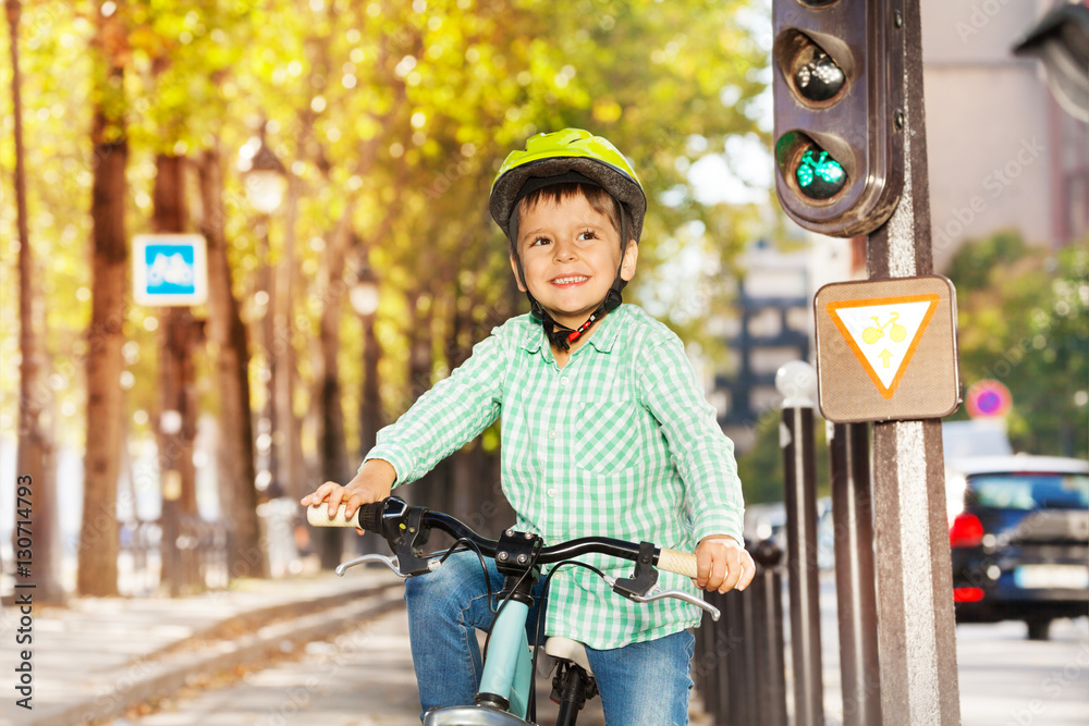 Cute boy riding his bike on green signal of lights