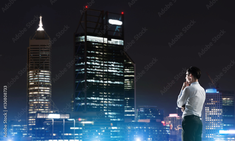 Businessman viewing night glowing city