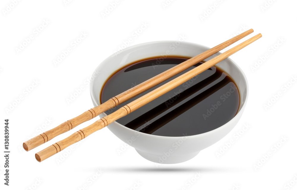 Soy sauce and chopsticks isolated on white