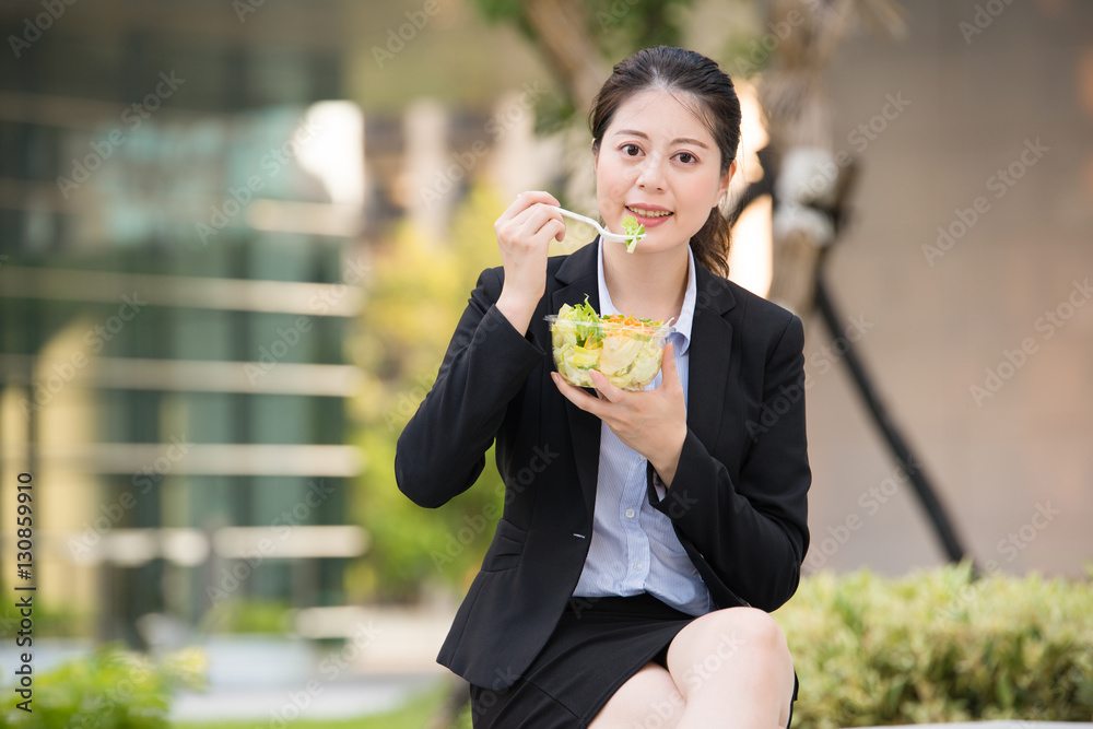 在公园长椅上吃沙拉的亚洲美女