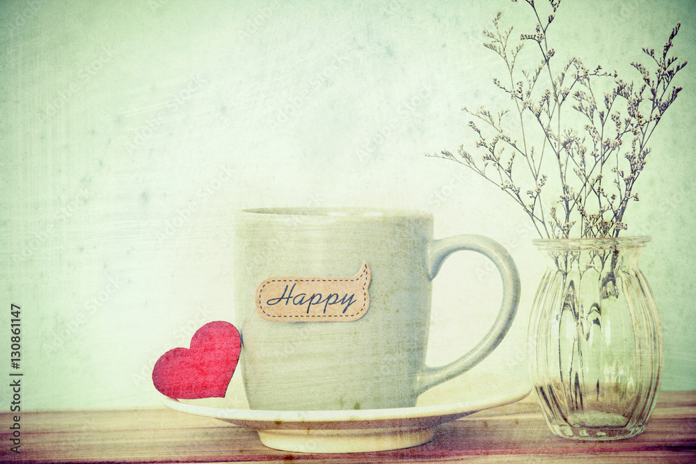 Coffee cup mug with red heart shapeand happy word tag on wooden