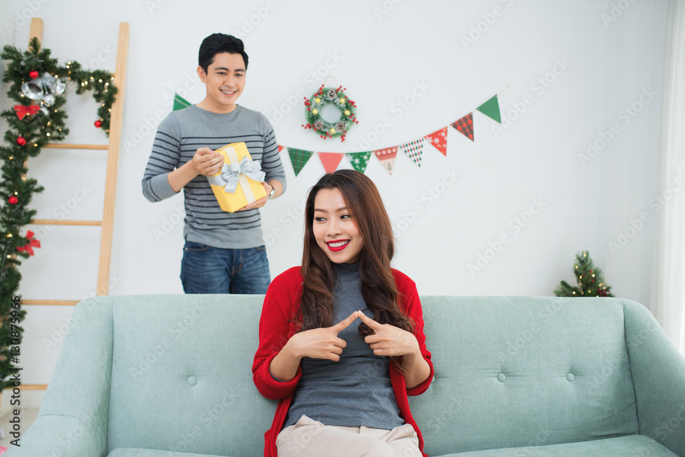 Christmas Asian Couple. A handsome man giving her girlfriend/wif