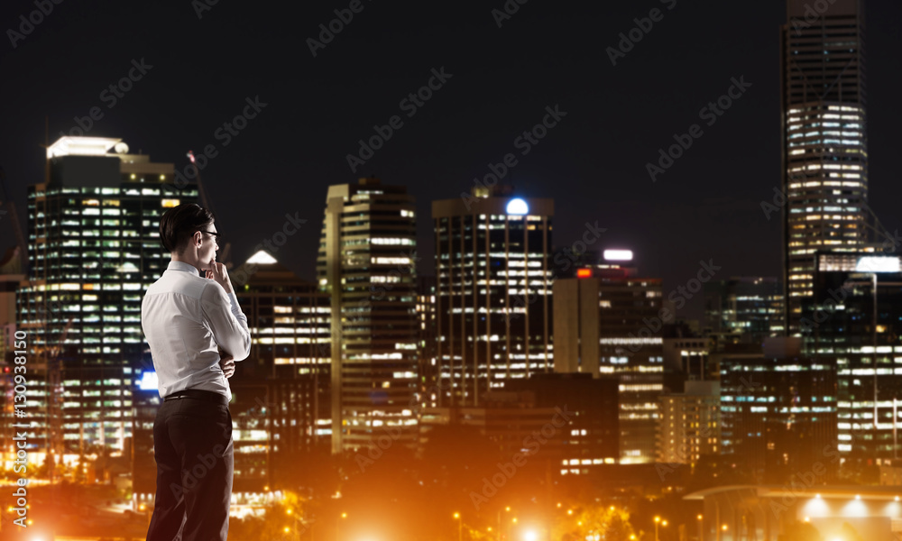 Businessman viewing night glowing city