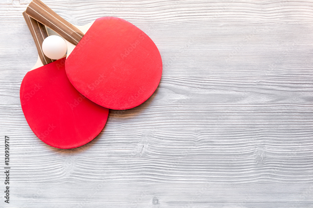 Red racket for ping pong ball wooden background top view