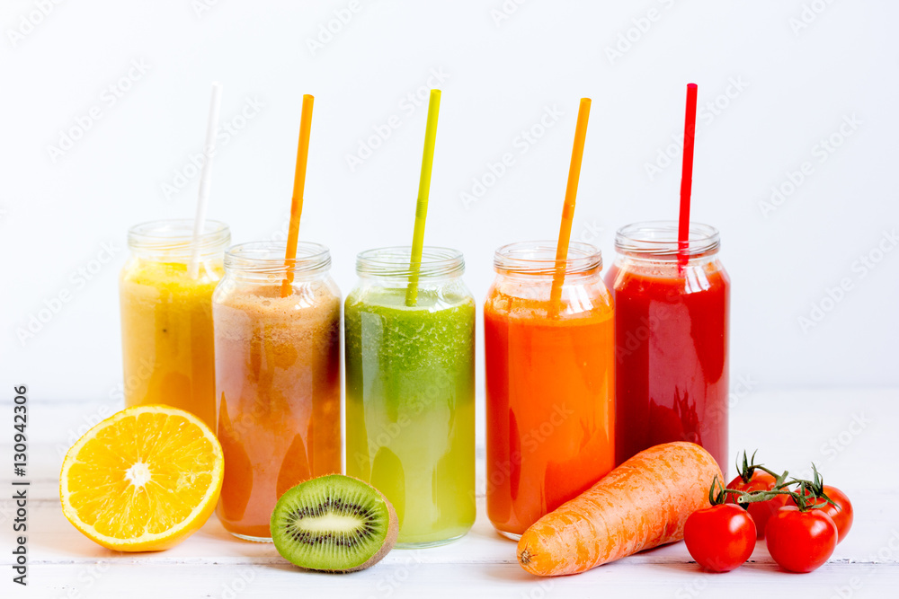 Fresh detox juices in glass bottles on white background