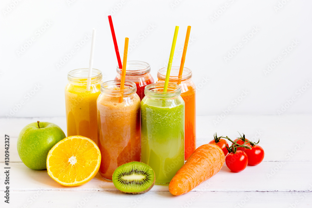 Fresh detox juices in glass bottles on white background