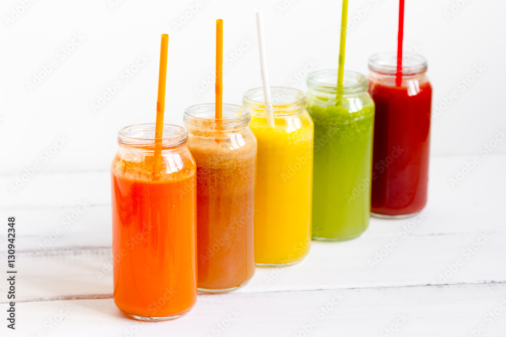 Fresh detox juices glass in row bottles on white background