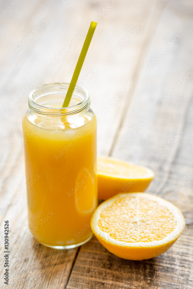 freshly squeezed orange juice in glass bottle on wooden background