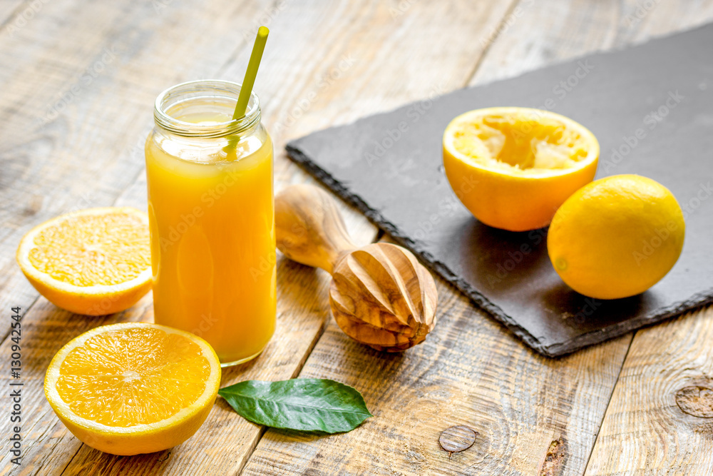 freshly squeezed orange juice in glass bottle on wooden background