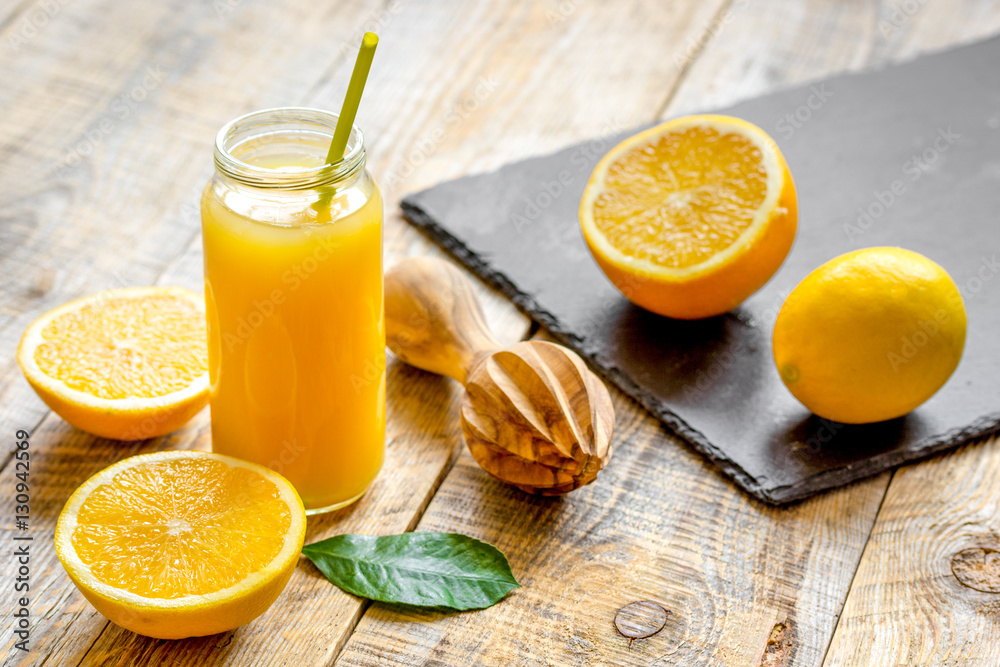 freshly squeezed orange juice in glass bottle on wooden background