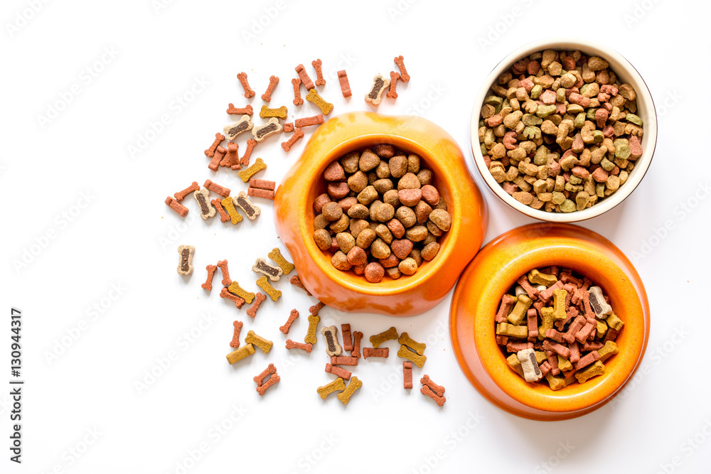 dry dog food in bowl on white background top view