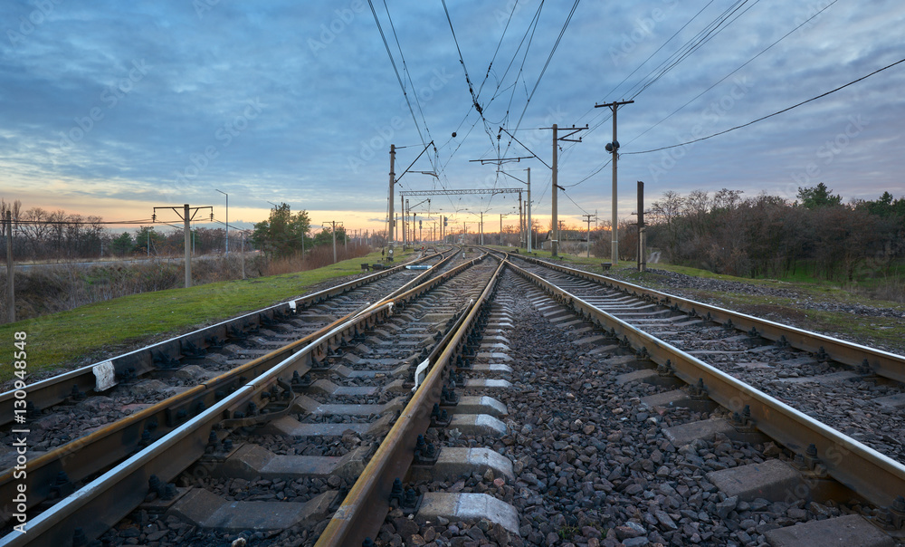 Railway station against beautiful sky at sunset. Industrial landscape with railroad, colorful cloudy