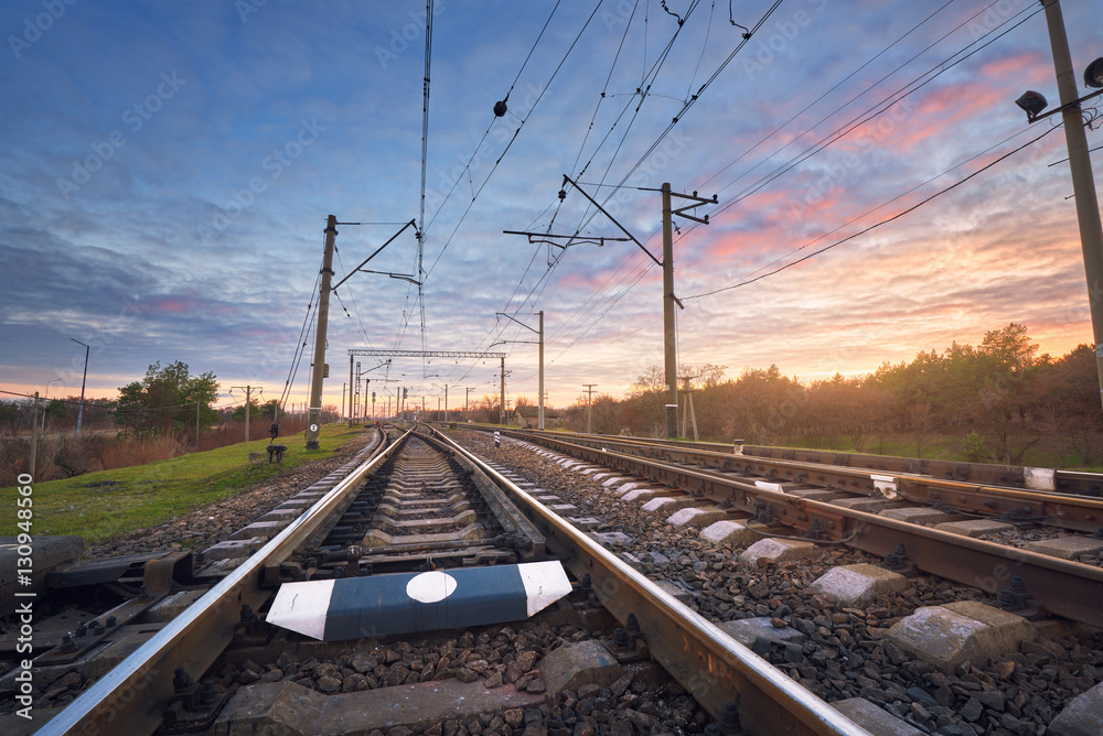 Railway station against beautiful sky at sunset. Industrial landscape with railroad, colorful blue s