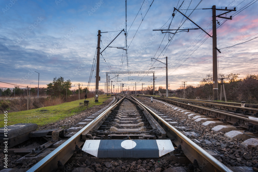 Railway station against beautiful sky at sunset. Industrial landscape with railroad and colorful clo