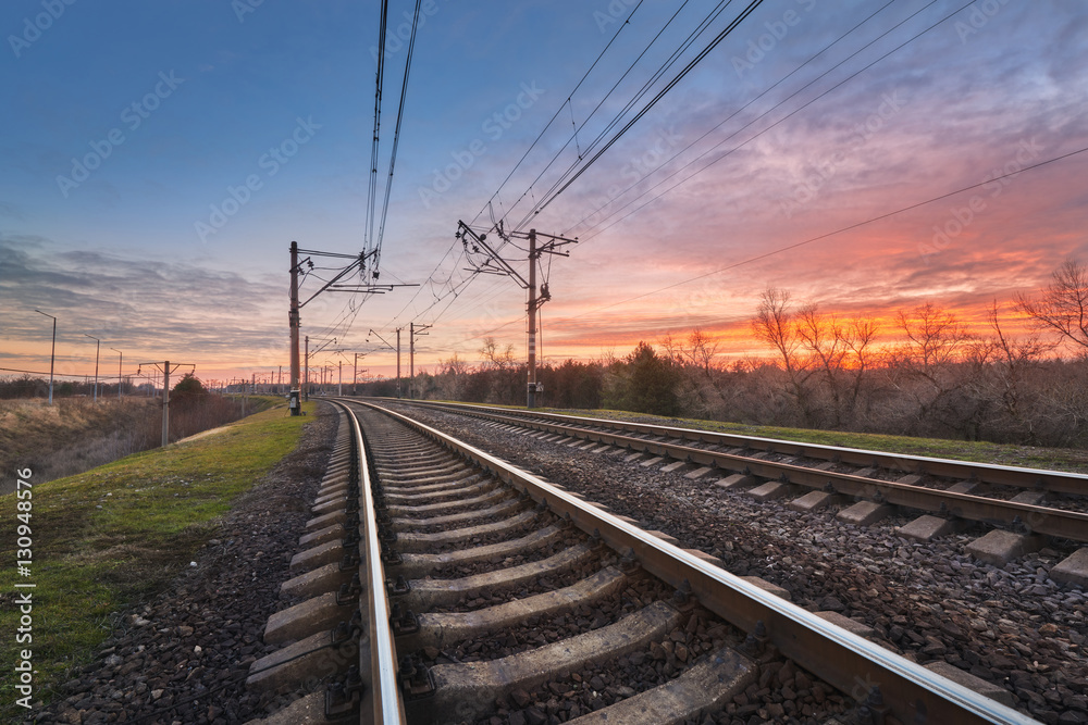 Railway station against beautiful sky at sunset. Industrial landscape with railroad, colorful blue s