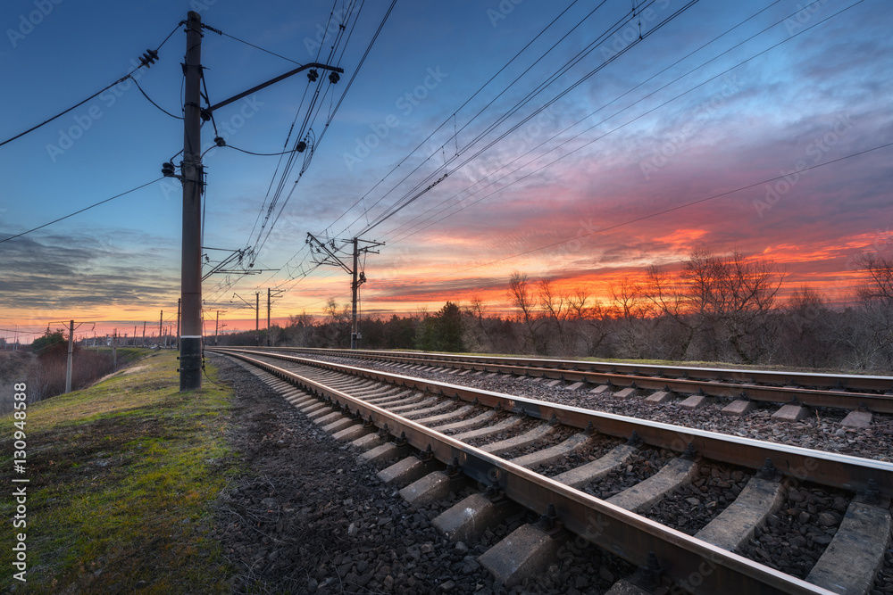 Railway station against beautiful sky at sunset. Industrial landscape with railroad, colorful blue s