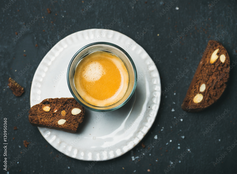 Glass of coffee espresso with chocolate and sea salt biscottii cookies over dark shabby stone backgr