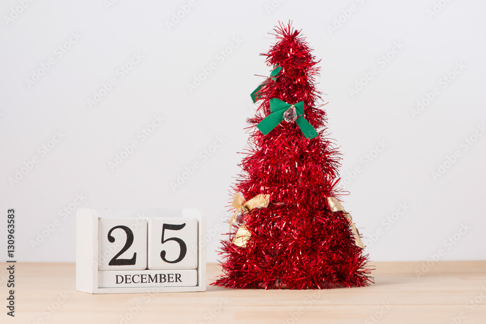 Red christmas tree on table with calendar 25 December