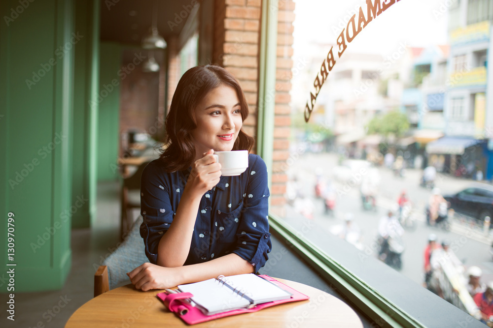 Portrait of happy young business woman with mug in hands drinkin