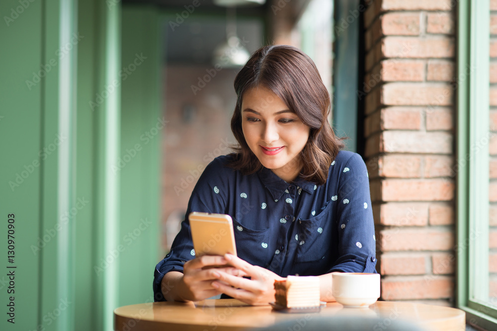 Beautiful cute asian young businesswoman in the cafe, using mobi