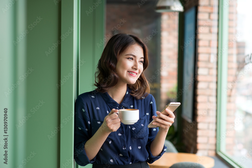 Beautiful cute asian young businesswoman in the cafe, using mobi