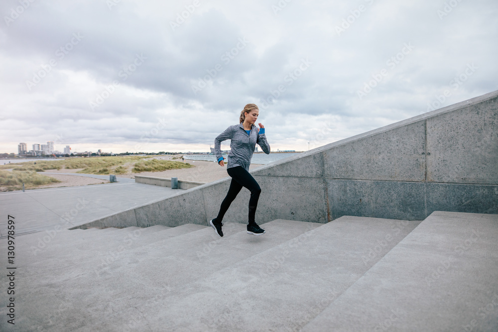 Fit young woman running up the steps