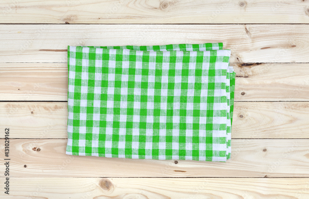 Green tablecloth on wooden table, top view