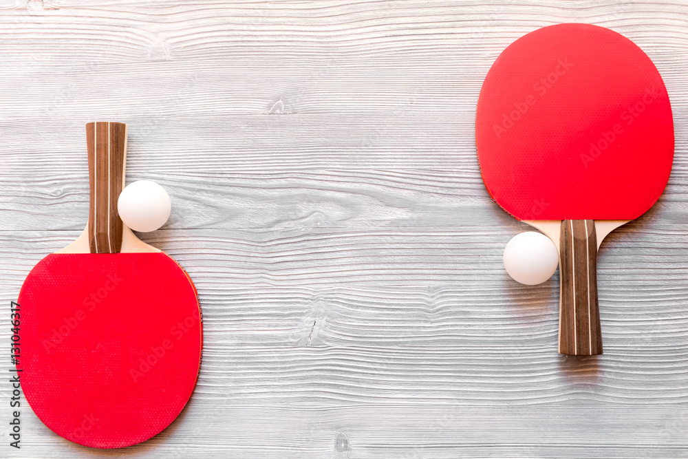 Red racket for ping pong ball wooden background top view