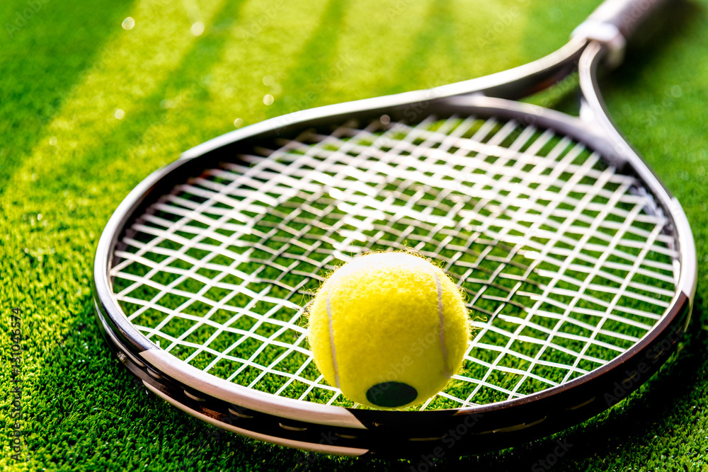 tennis racket on green background close up