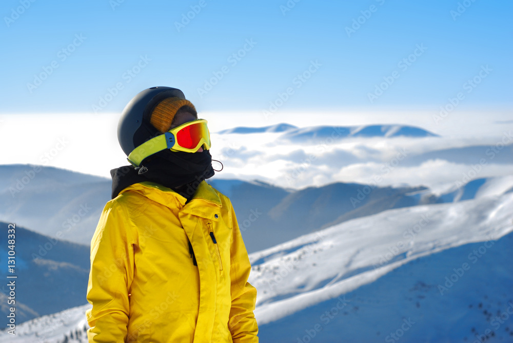 girl in a mask for snowboarding and helmet against the backdrop