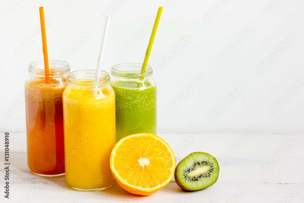 Fresh detox juices in glass bottles on white background