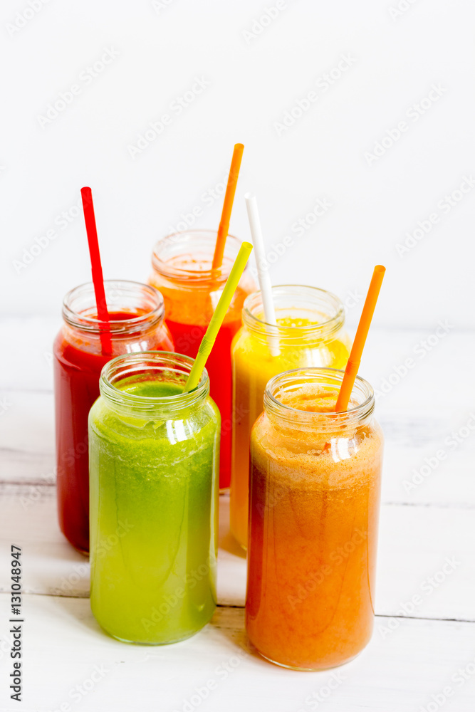 Fresh detox juices in glass bottles on white background