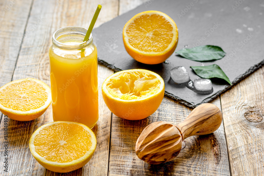 freshly squeezed orange juice in glass bottle on wooden background