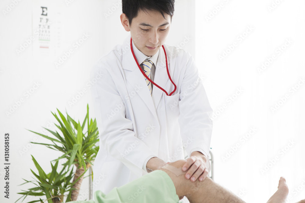 The doctor is examining the males knee