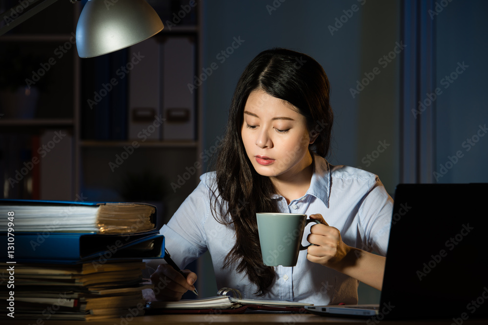 asian business woman drink coffee working overtime late night