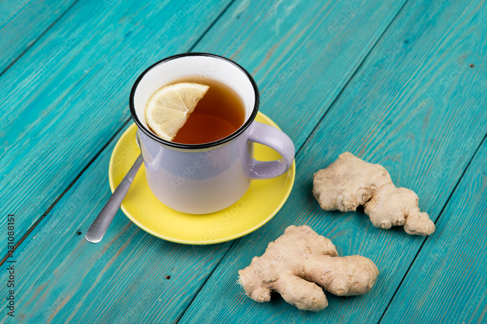 Ginger tea in a cup on wooden background