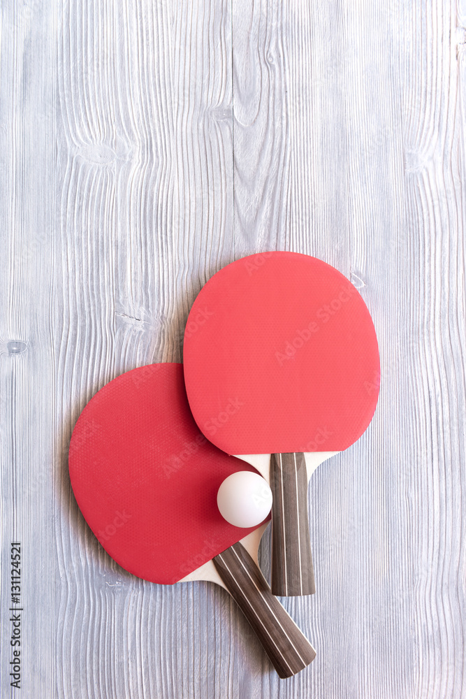 Red racket for ping pong ball wooden background top view