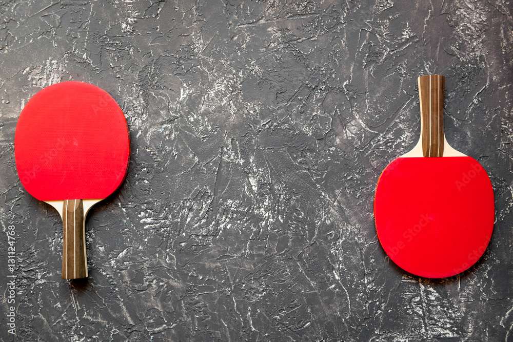 Red racket for ping pong ball gray background top view